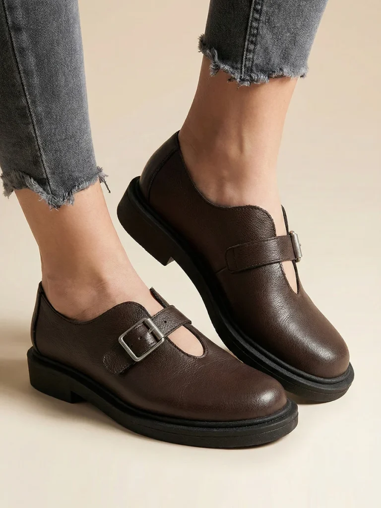 Brązowe skórzane półbuty damskie Vesta w stylu barefoot z szerokim noskiem i srebrną klamrą na grubszej podeszwie.