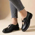 Czarne skórzane półbuty damskie Vesta w stylu barefoot z szerokim noskiem i srebrną klamrą na grubszej podeszwie.